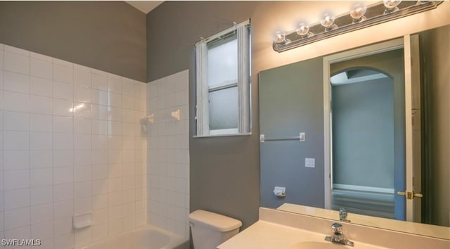 full bathroom with vanity, tiled shower / bath, and toilet