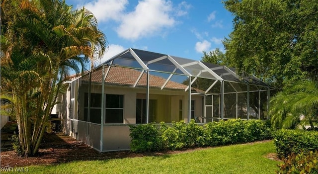 back of house featuring a yard and a lanai