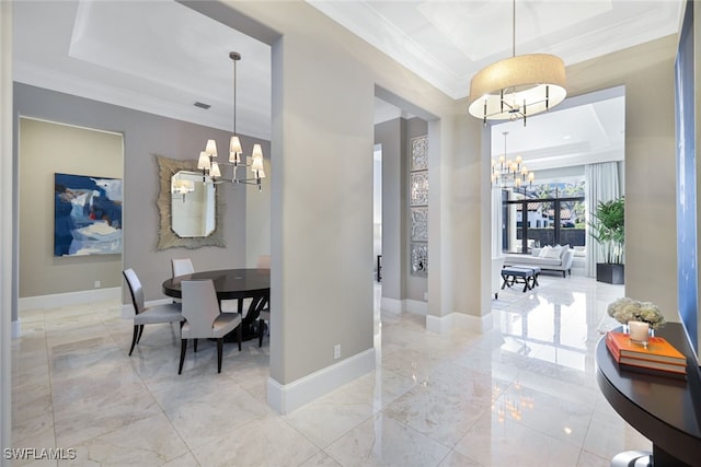 dining area featuring a notable chandelier, crown molding, and a raised ceiling