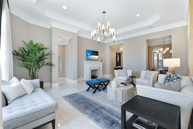 living room with ornamental molding, a notable chandelier, and a tray ceiling