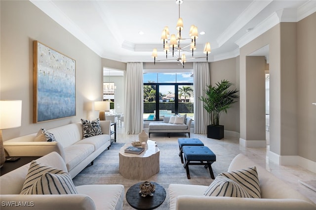 living room with an inviting chandelier, a tray ceiling, and ornamental molding