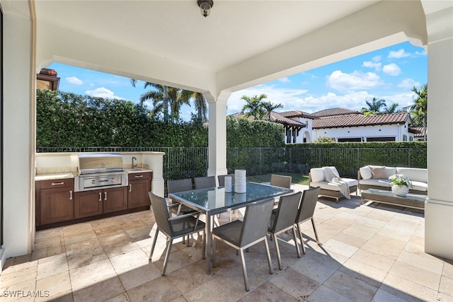 view of patio / terrace with an outdoor kitchen, a grill, an outdoor living space, and sink