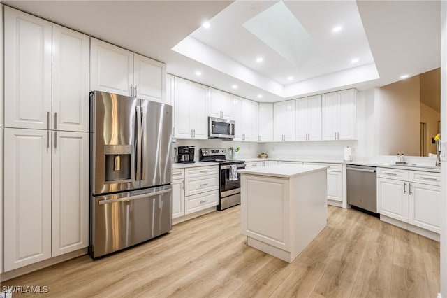 kitchen featuring white cabinetry, stainless steel appliances, and a raised ceiling