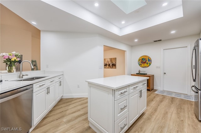 kitchen with white cabinetry, sink, stainless steel appliances, and light hardwood / wood-style floors