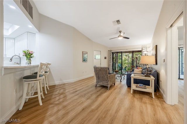 sitting room featuring ceiling fan, lofted ceiling, and light wood-type flooring