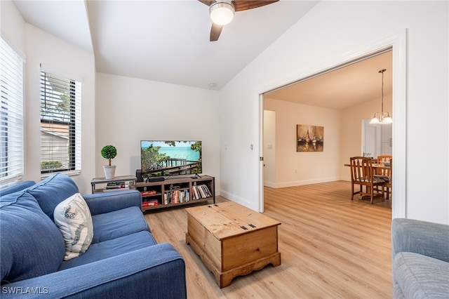 living room featuring hardwood / wood-style flooring, lofted ceiling, and ceiling fan with notable chandelier