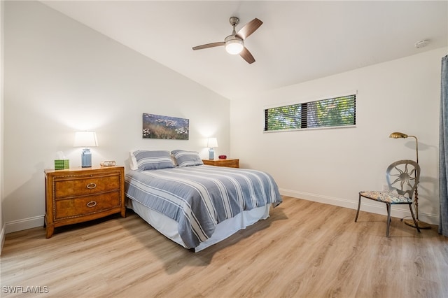 bedroom featuring light hardwood / wood-style flooring, vaulted ceiling, and ceiling fan