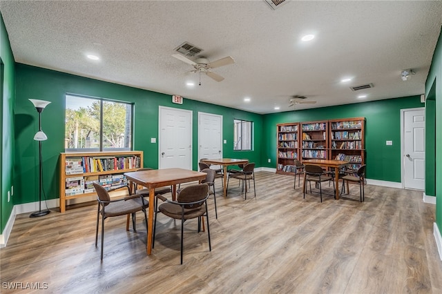 dining room featuring ceiling fan, light hardwood / wood-style flooring, and a textured ceiling