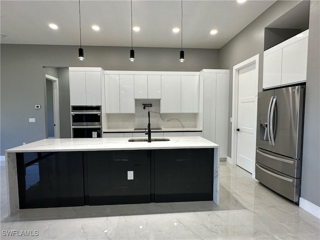 kitchen with stainless steel appliances, hanging light fixtures, and a center island with sink