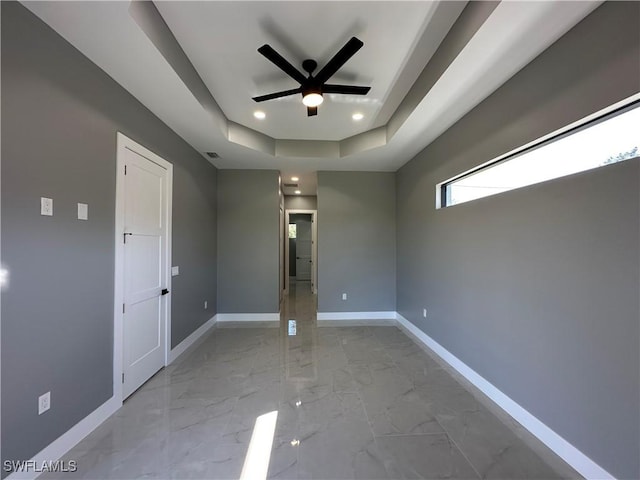 unfurnished room with a raised ceiling and ceiling fan