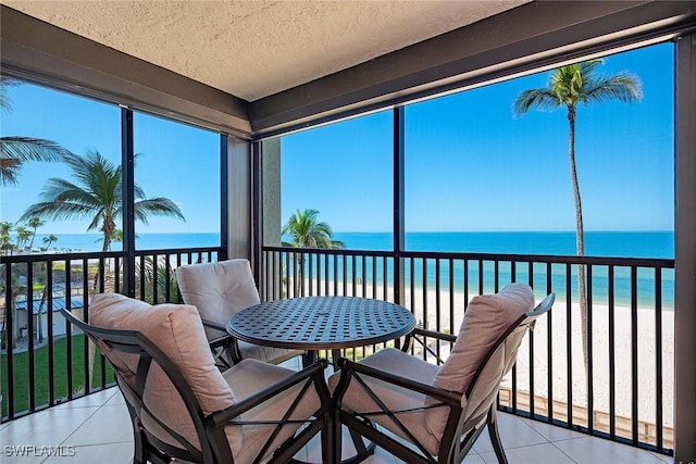 sunroom with a view of the beach and a water view