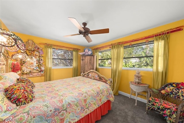 bedroom featuring multiple windows, ceiling fan, and dark carpet