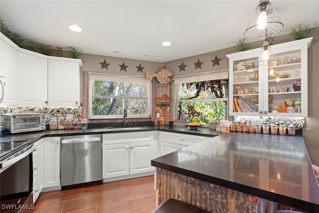 kitchen featuring pendant lighting, stainless steel appliances, sink, and white cabinets