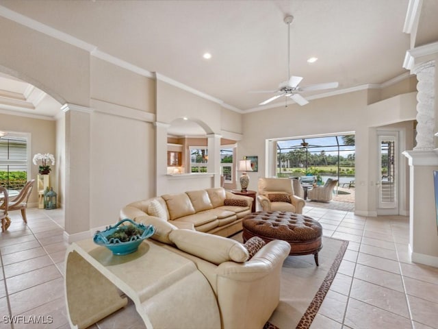 tiled living room featuring crown molding, plenty of natural light, and ornate columns