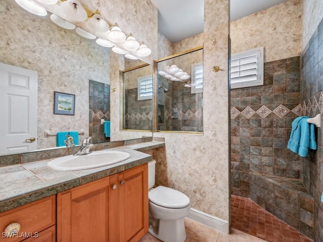 bathroom with vanity, tiled shower, tile patterned floors, and toilet