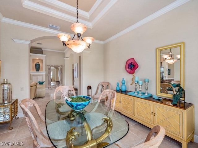 dining area with crown molding, light tile patterned floors, a chandelier, and a tray ceiling