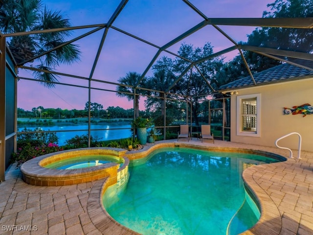 pool at dusk featuring a lanai, an in ground hot tub, a patio, and a water view