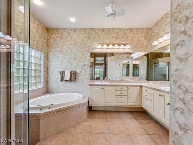 bathroom featuring tile patterned flooring, vanity, tiled bath, and ceiling fan