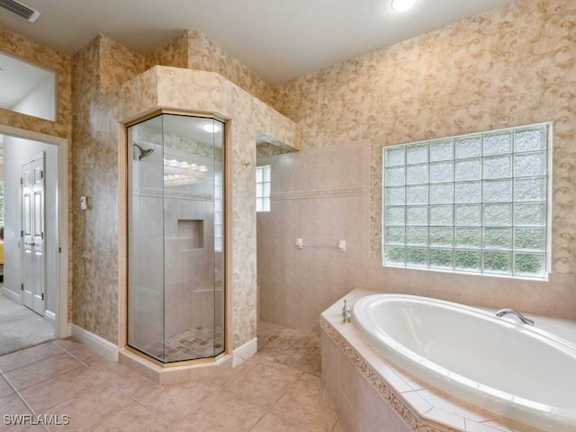 bathroom featuring tile patterned flooring and shower with separate bathtub