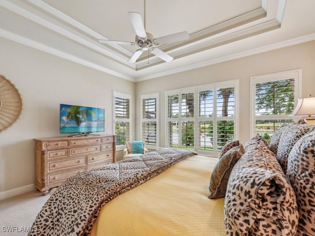 bedroom with crown molding, light carpet, ceiling fan, and a tray ceiling