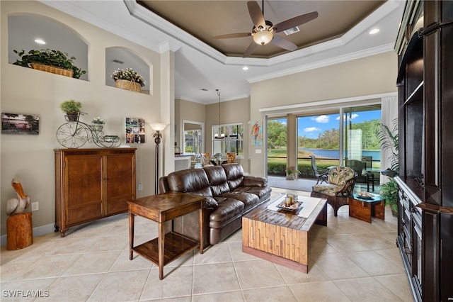 living room featuring ceiling fan, a raised ceiling, crown molding, and light tile patterned flooring