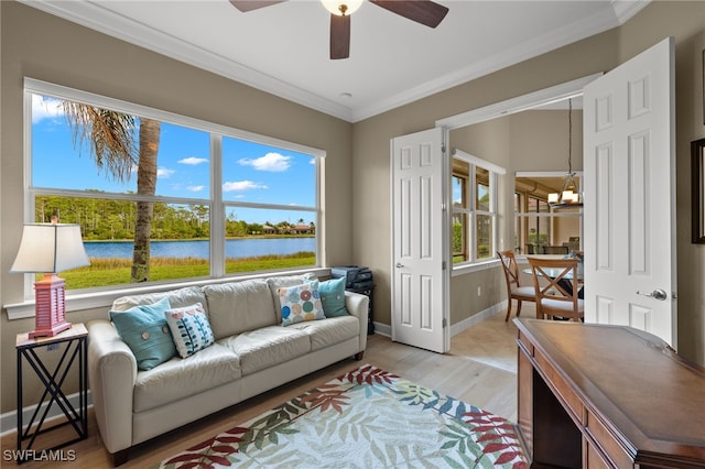 living room with hardwood / wood-style flooring, crown molding, a water view, and ceiling fan with notable chandelier