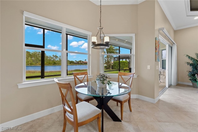 dining room with a water view, crown molding, an inviting chandelier, and light tile patterned floors