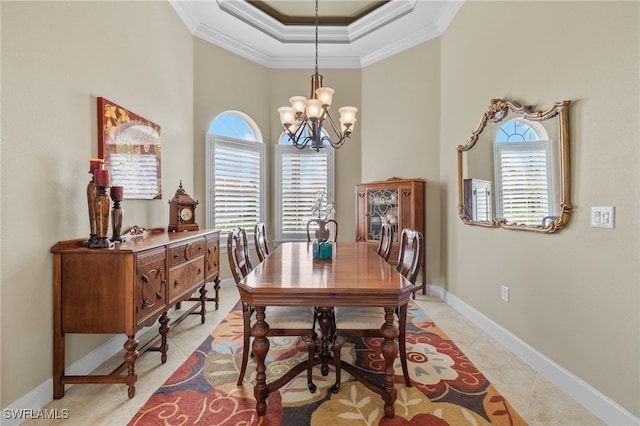 dining room featuring a notable chandelier, a tray ceiling, ornamental molding, and light tile patterned flooring