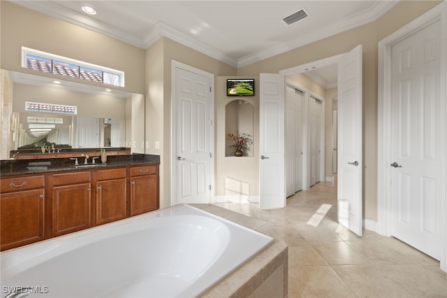 bathroom with vanity, tiled tub, crown molding, and tile patterned floors