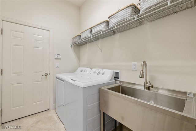 laundry area featuring sink, washing machine and dryer, and light tile patterned flooring