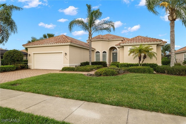 mediterranean / spanish house featuring a garage and a front yard