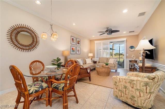 dining space featuring crown molding and ceiling fan with notable chandelier