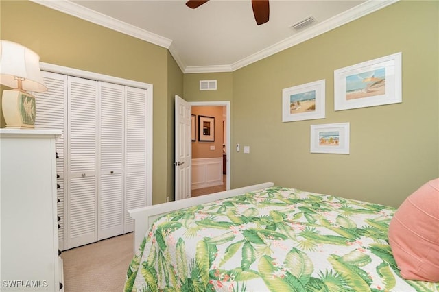 bedroom featuring crown molding, a closet, ceiling fan, and light carpet