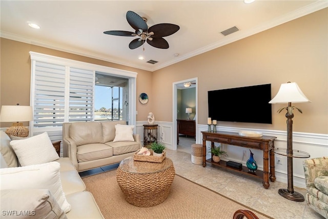 tiled living room with ornamental molding and ceiling fan