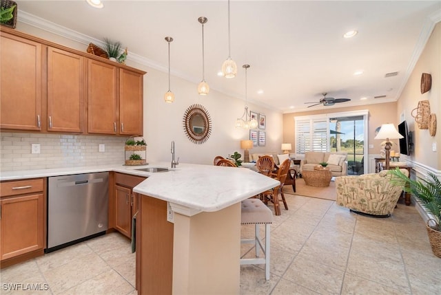 kitchen with a breakfast bar, ornamental molding, dishwasher, and sink