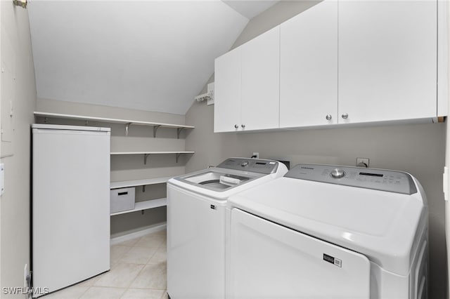 laundry area with light tile patterned flooring, cabinet space, and separate washer and dryer