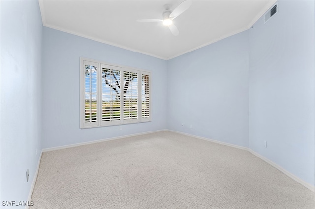 carpeted empty room featuring ceiling fan, ornamental molding, visible vents, and baseboards