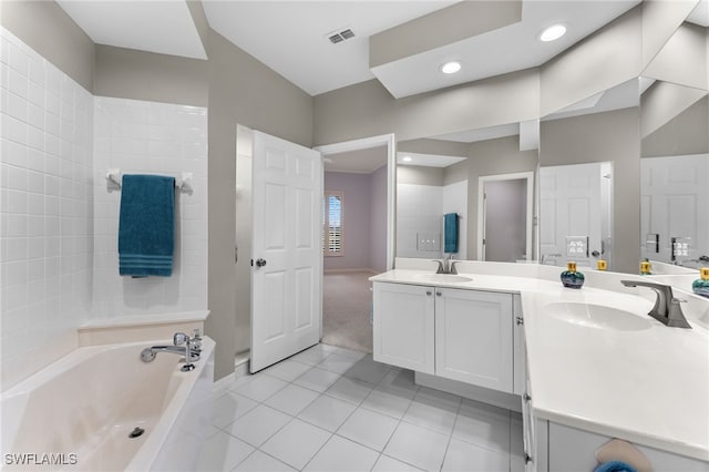 bathroom featuring tile patterned flooring, vanity, and a tub to relax in