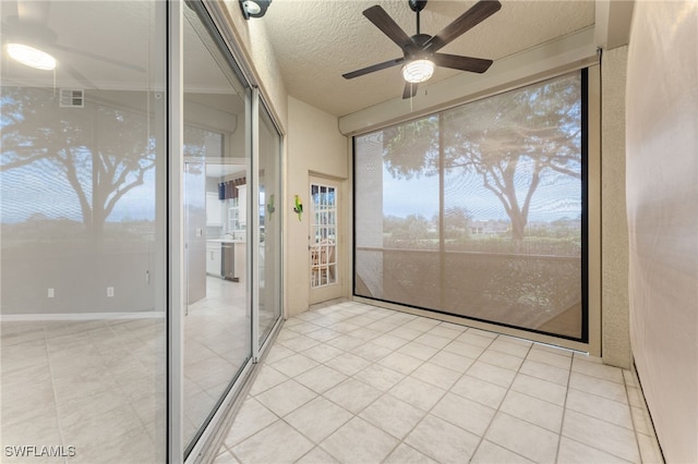 interior space featuring ceiling fan, tile patterned floors, and a textured ceiling