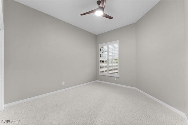 unfurnished room with light carpet, baseboards, and a ceiling fan