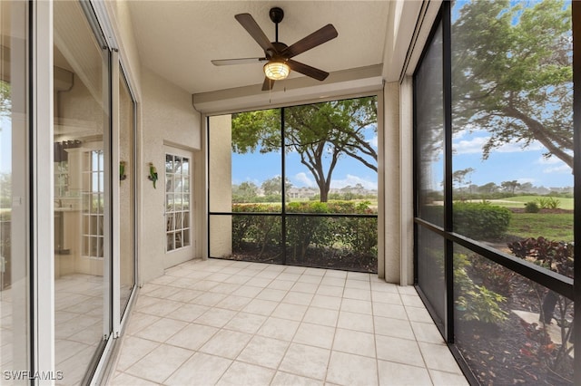 unfurnished sunroom featuring ceiling fan