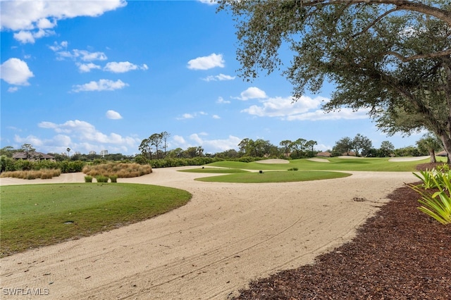 surrounding community with view of golf course, driveway, and a lawn