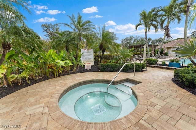 view of swimming pool with a hot tub