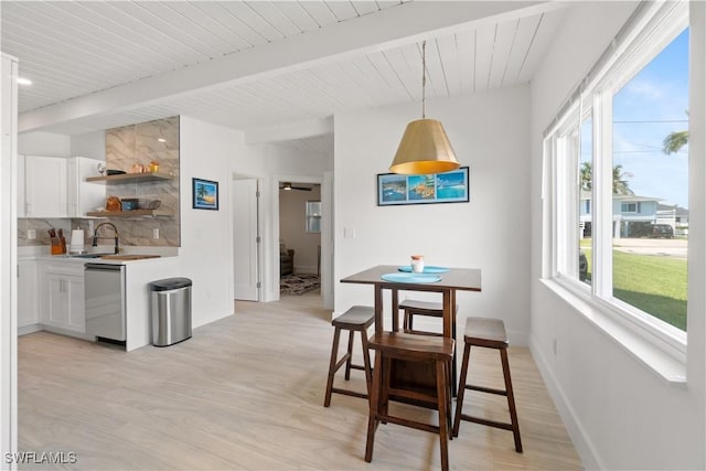 dining room featuring sink, wooden ceiling, beam ceiling, and light hardwood / wood-style floors