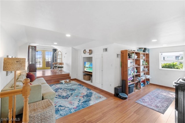 living room with french doors, a healthy amount of sunlight, and light wood-type flooring