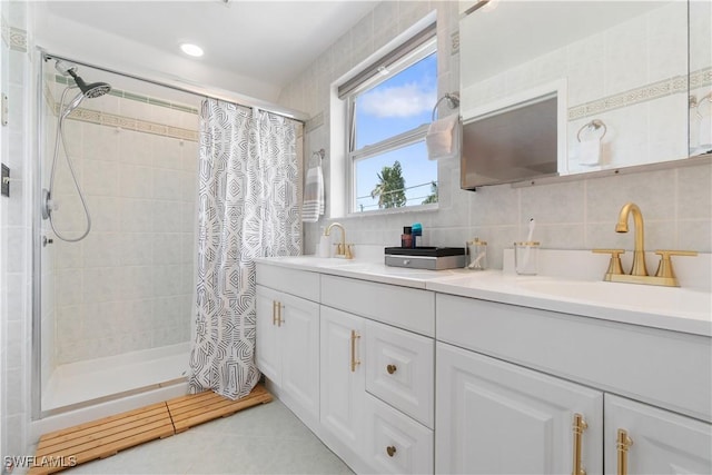 bathroom featuring tasteful backsplash, vanity, tile walls, and walk in shower