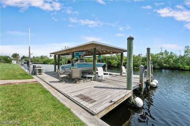 view of dock with a water view and a yard