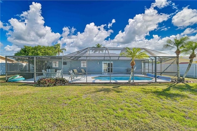 back of house featuring a fenced in pool, a lanai, a patio, and a yard