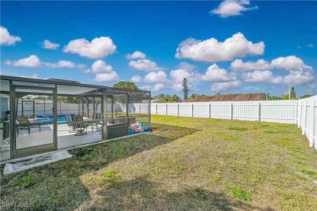 view of yard featuring a swimming pool, a patio, and glass enclosure