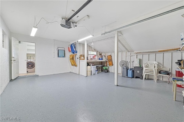 garage featuring a garage door opener and washer / dryer